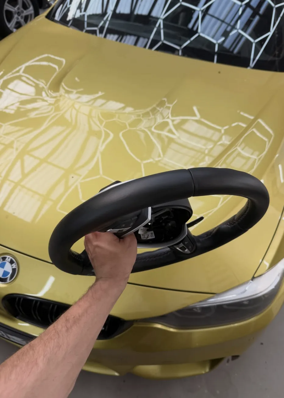 Goldener BMW bei professioneller Fahrzeugpflege
