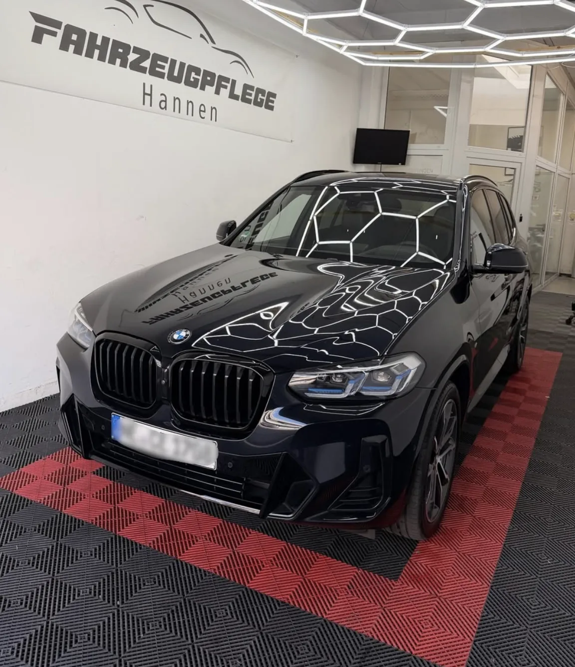 Dunkler BMW SUV im Studio von Fahrzeugpflege Hannen