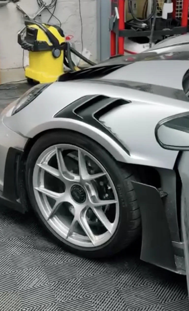 Silberner Porsche bei professioneller Lack- und Felgenpflege